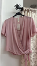 Camiseta rosa cruzada con lazada lateral — fotografía del producto