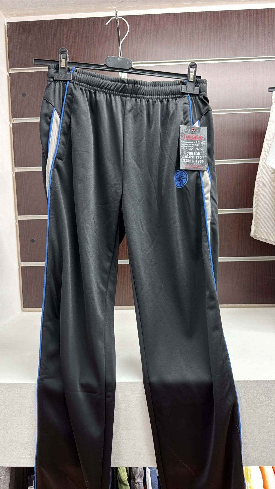Pantalón deportivo juvenil negro con franjas azules — fotografía del producto