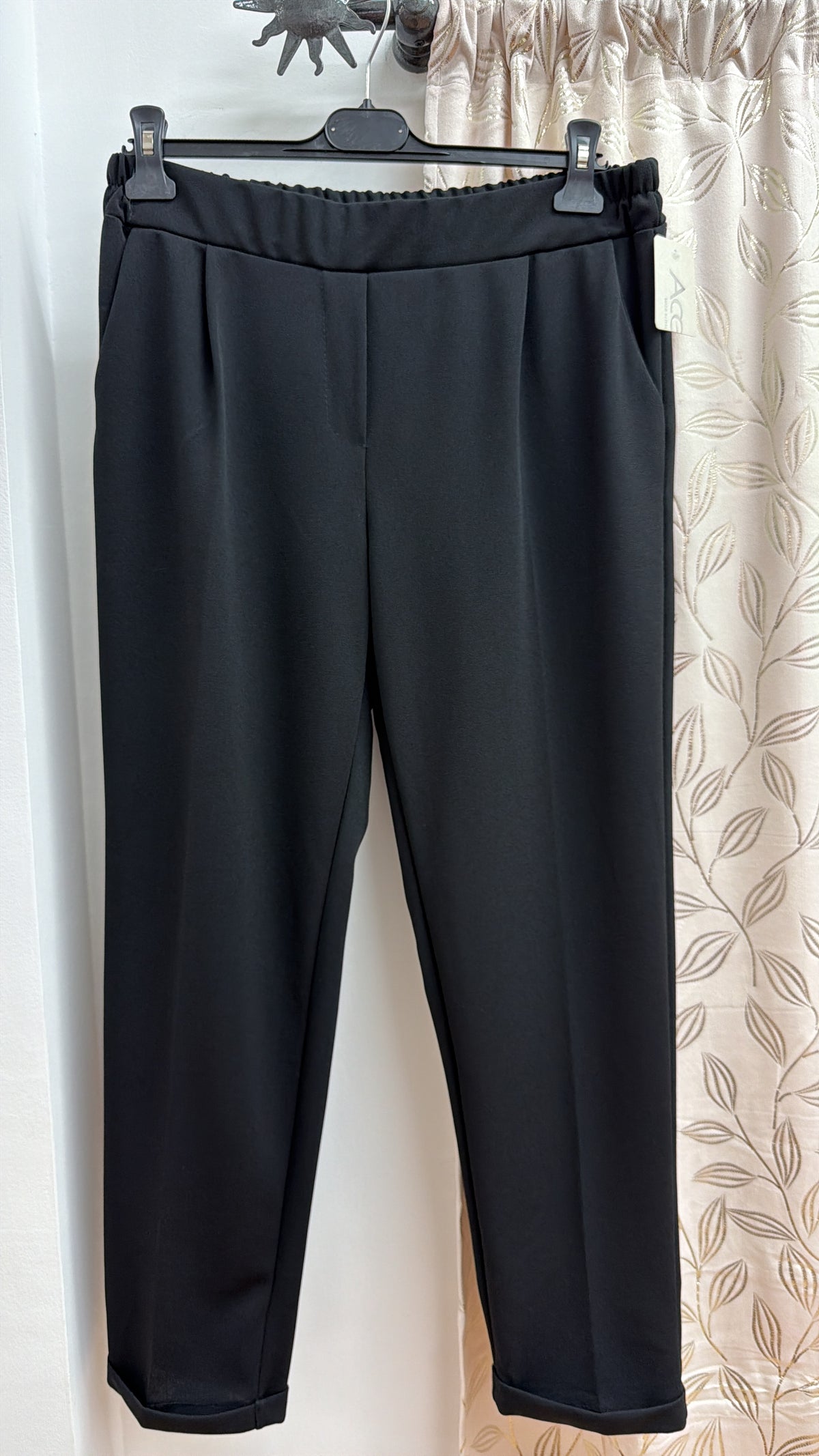Pantalón fluido negro con bajo vuelt — fotografía del producto