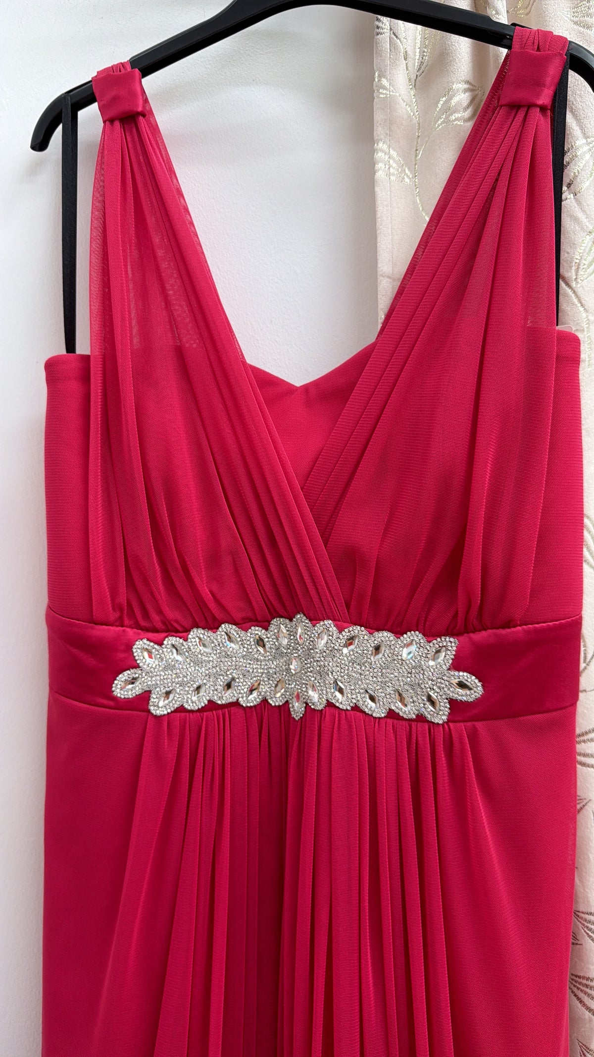 Vestido largo de fiesta fucsia con escote cruzado y detalle joya — fotografía del producto