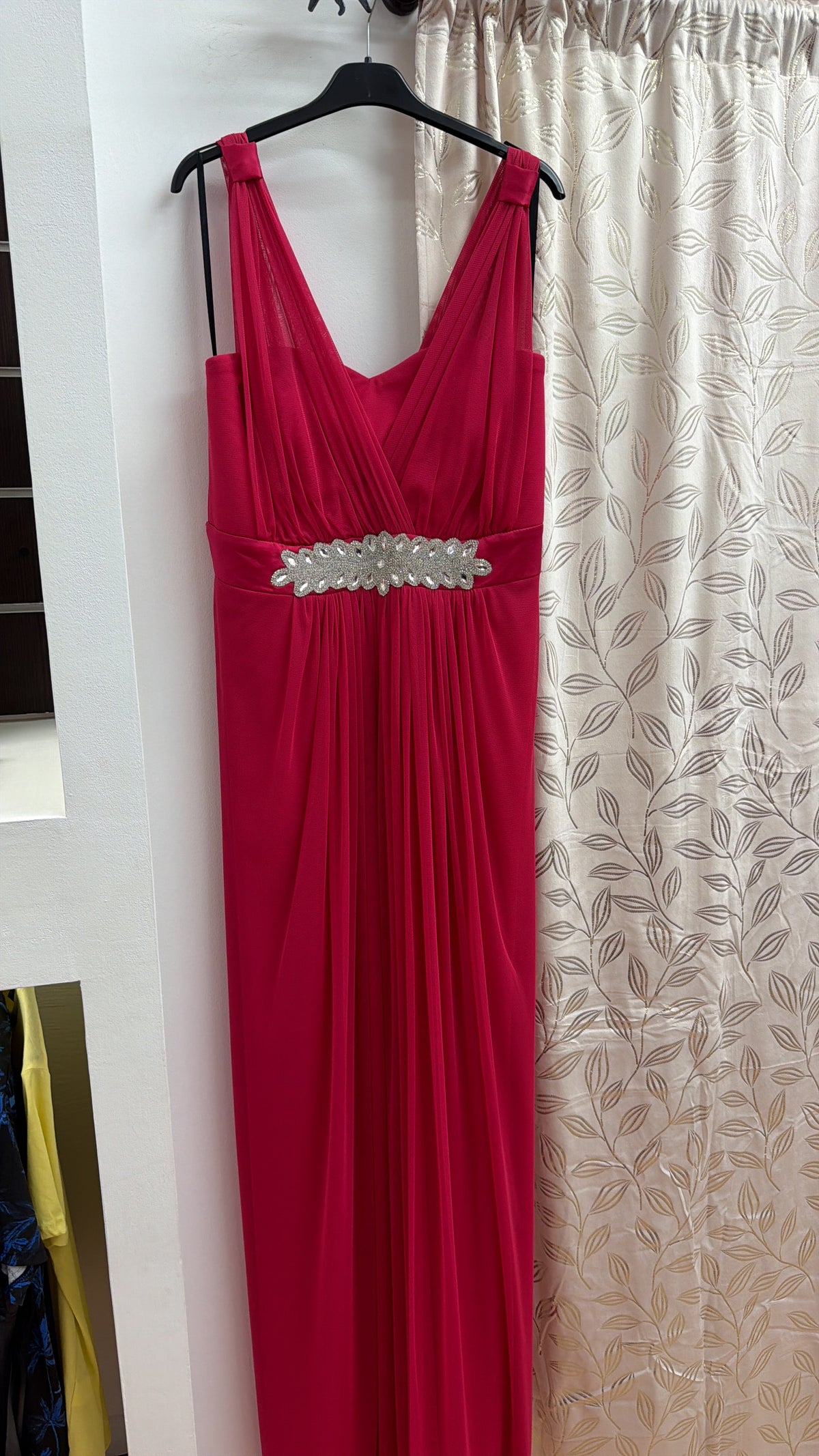 Vestido largo de fiesta fucsia con escote cruzado y detalle joya — fotografía del producto