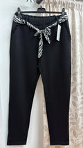 Pantalón negro con cinturón estampado cebra — fotografía del producto