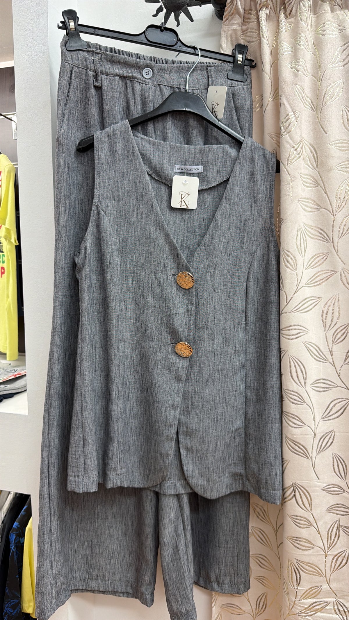 Conjunto gris de chaleco y pantalón con botones efecto madera — fotografía del producto