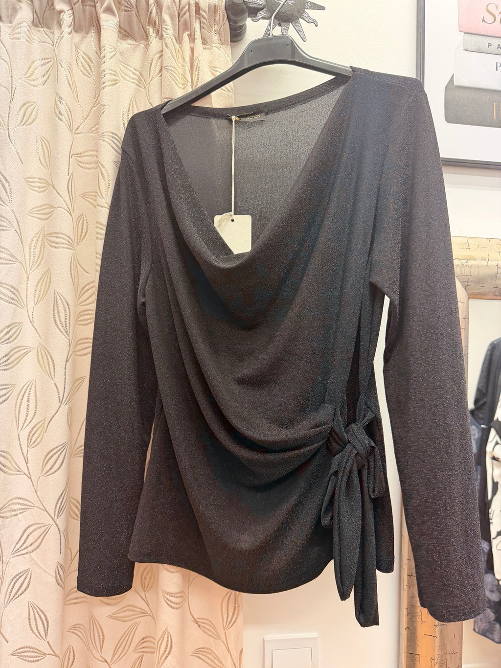 Blusa negra de mujer de manga larga con escote drapeado y lazada lateral