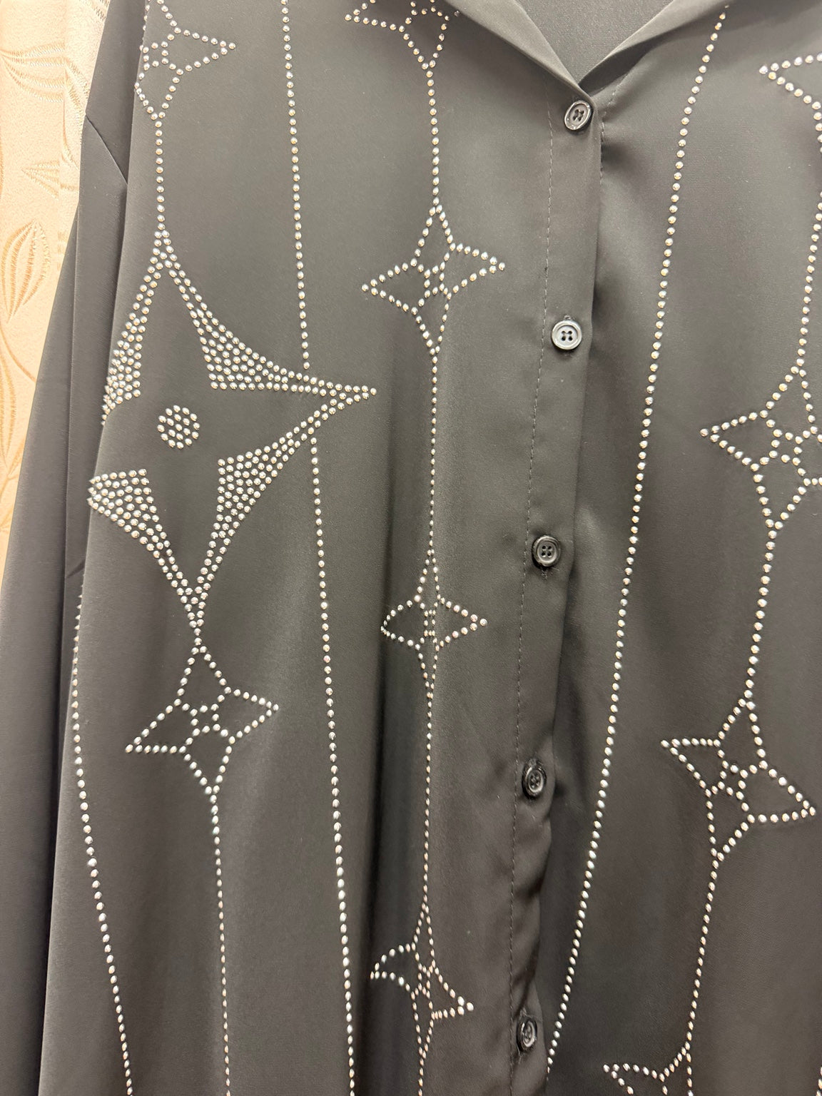 Detalle de strass en forma de estrellas de blusa negra de mujer