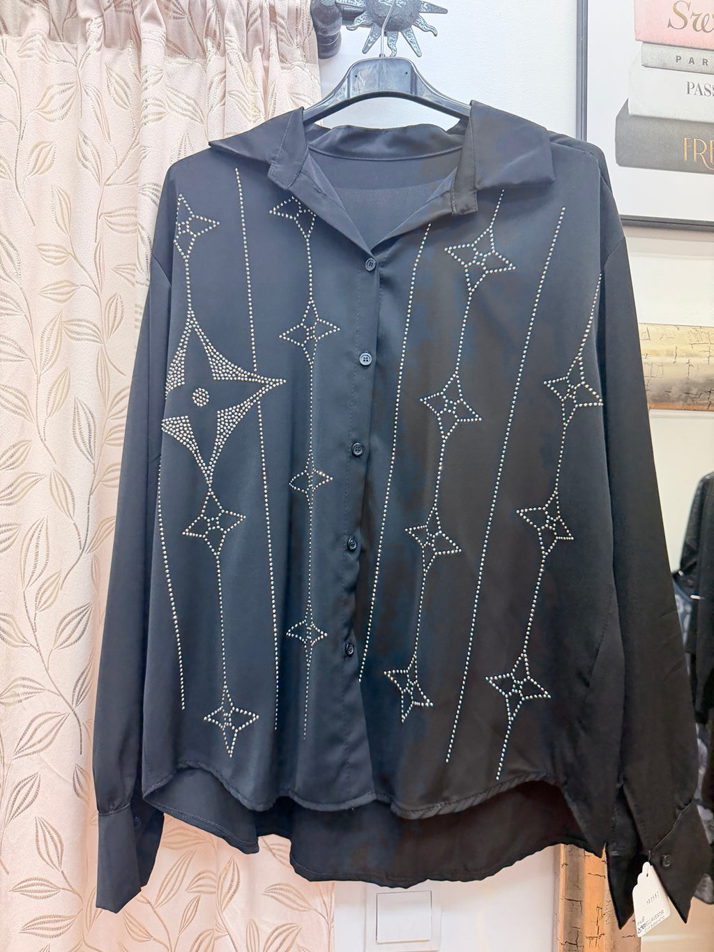 Blusa negra de mujer con cuello camisero y decoración de strass en estrellas