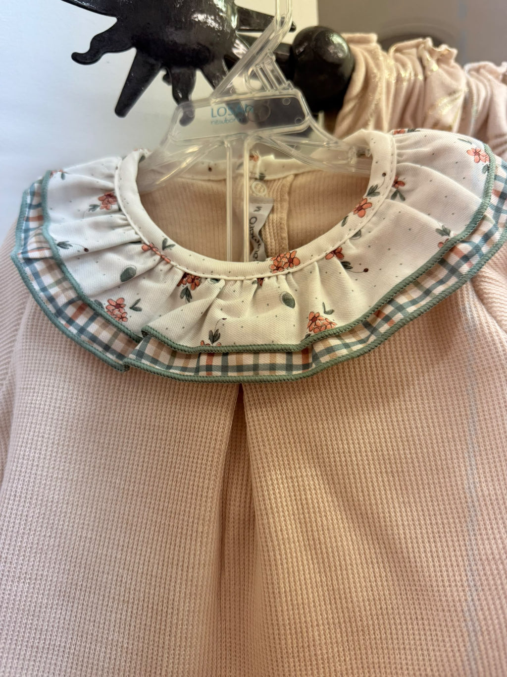 Detalle del cuello con doble volante floral y de cuadros del conjunto bebé Calamaro