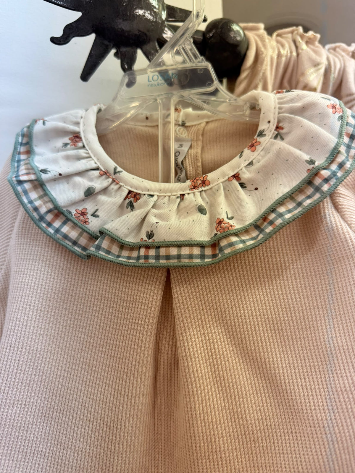 Detalle del cuello con doble volante floral y de cuadros del conjunto bebé Calamaro
