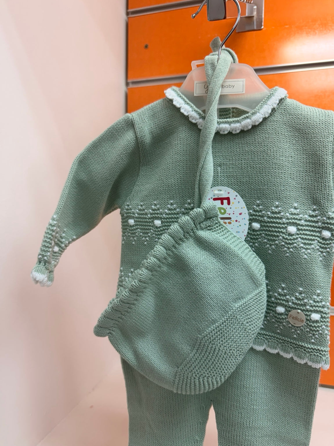 Detalle del conjunto bebé Felicia verde empolvado y blanco