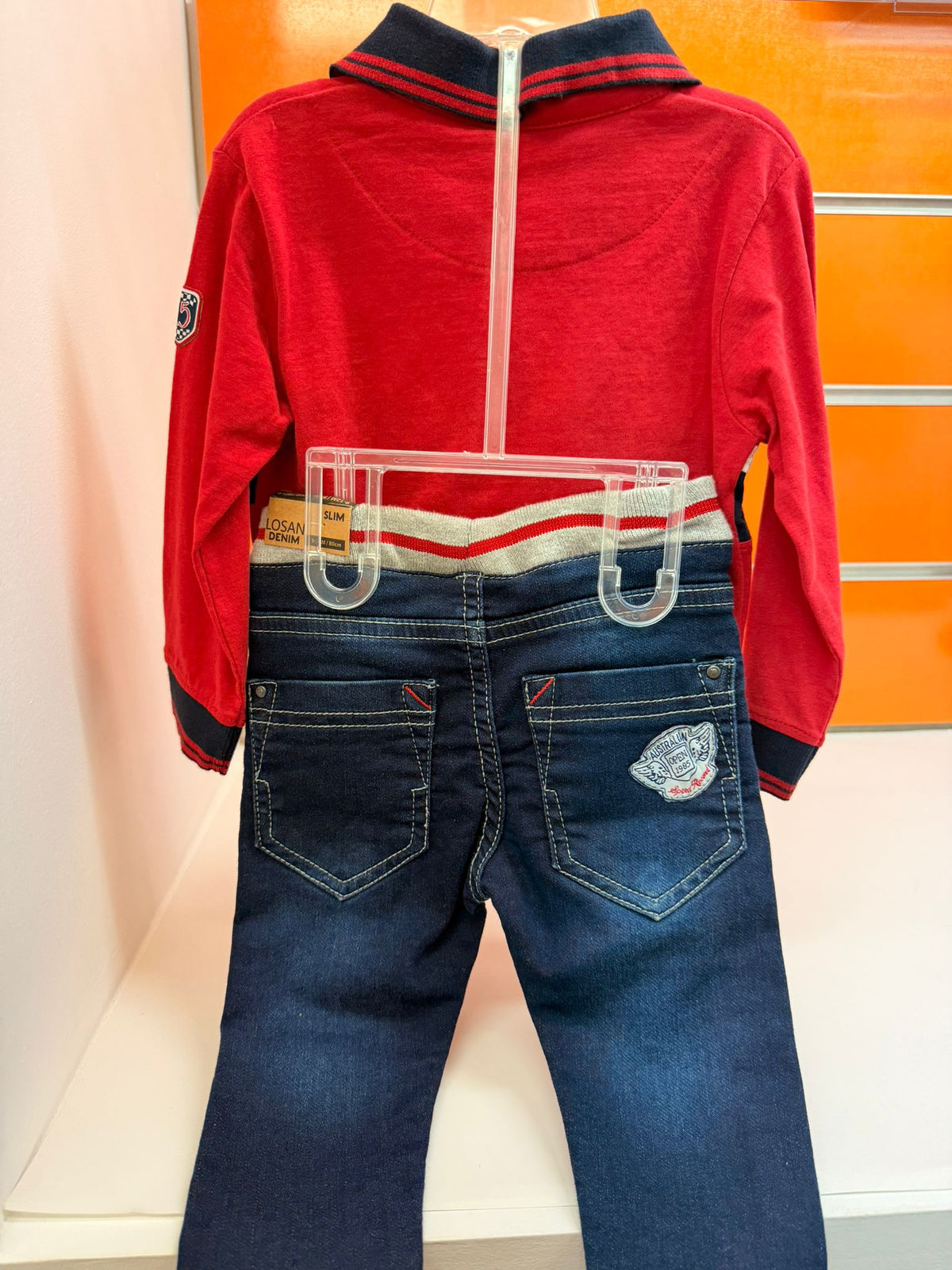 Vista trasera del conjunto bebé Losan con polo rojo y pantalón vaquero