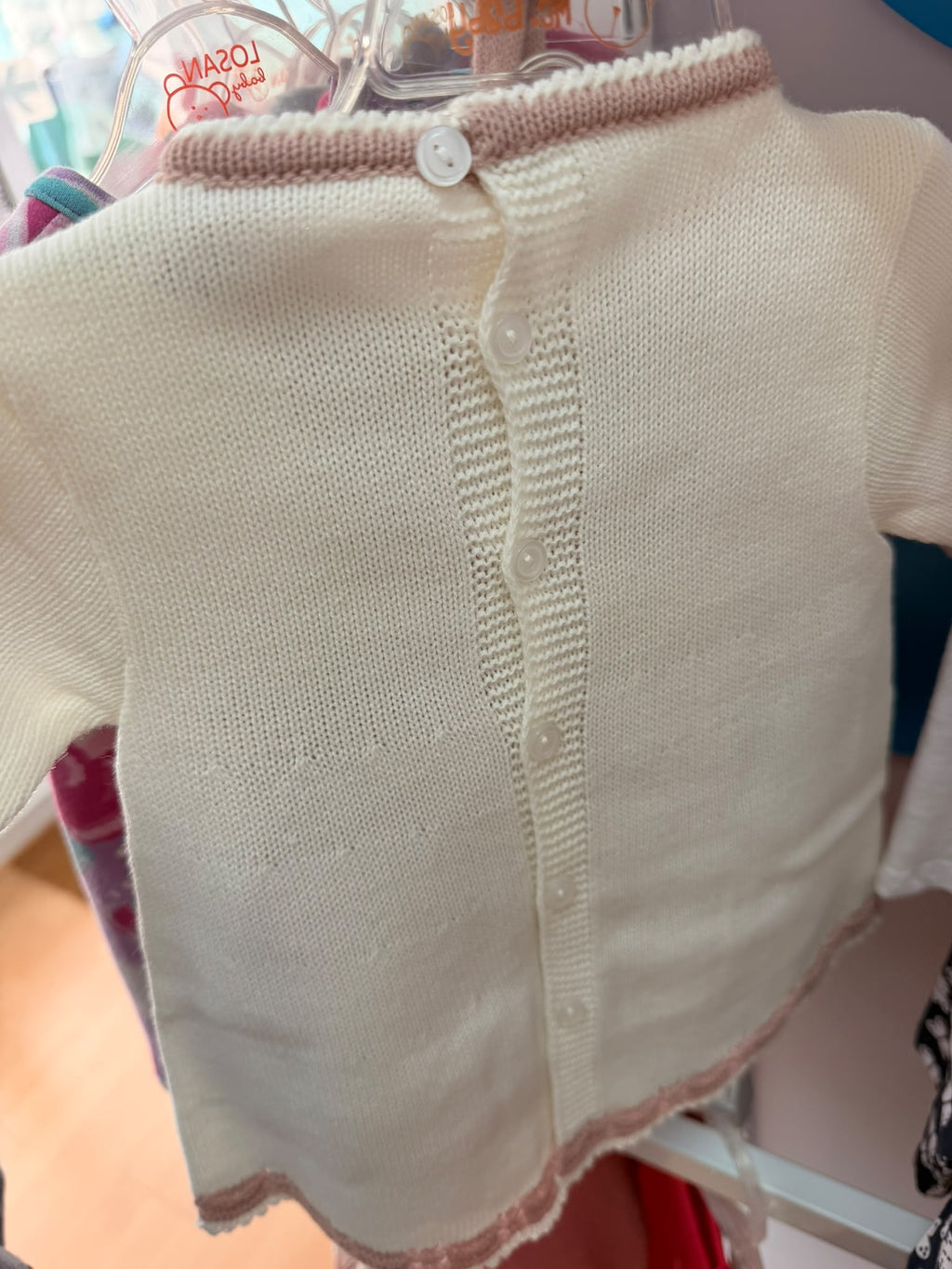 Vista trasera del vestido de bebé Felicia crudo y maquillaje