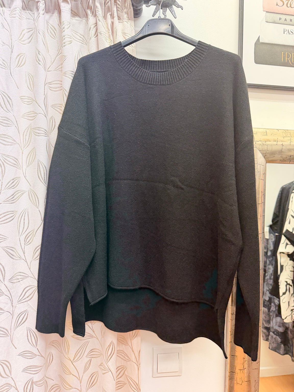 Jersey de mujer negro oversize con bolsillo delantero y bajo asimétrico