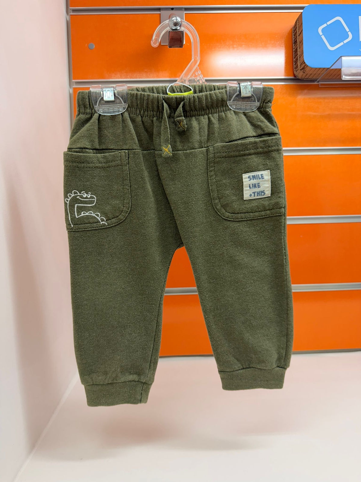 Pantalón bebé Losan verde caqui con bolsillos y detalle de dinosaurio