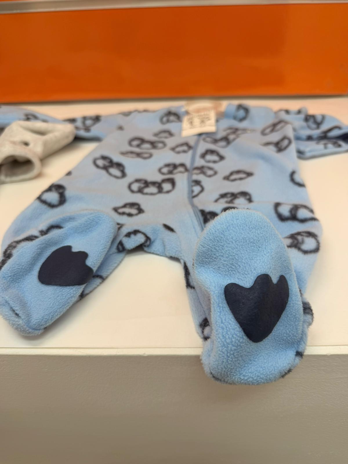 Detalle de los pies del pelele de bebé Losan azul con pingüinos
