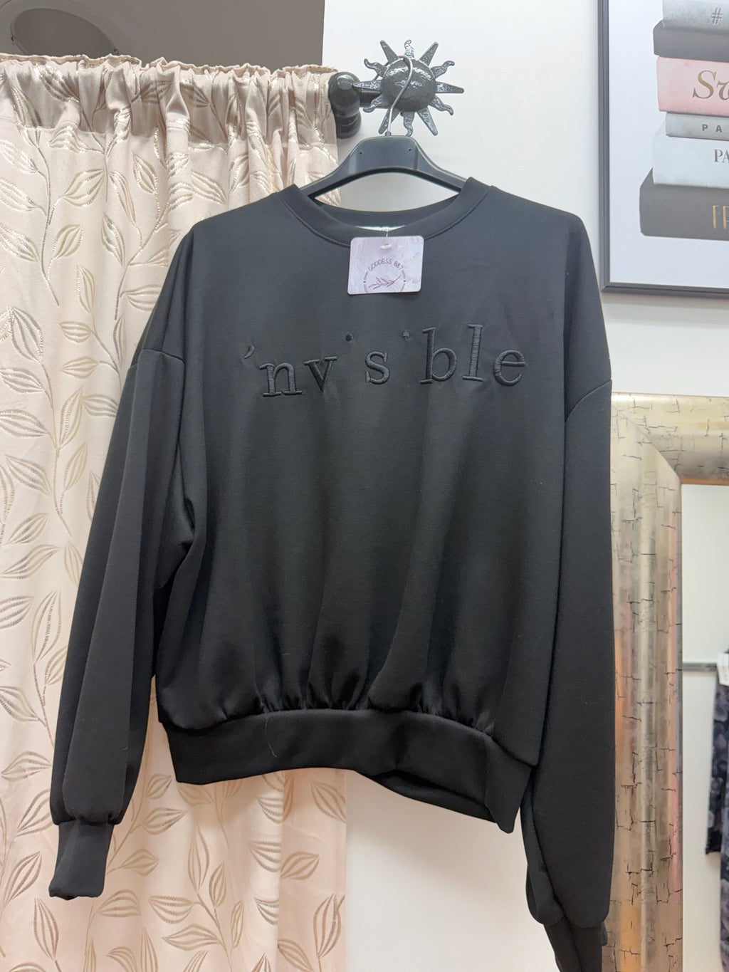 Sudadera negra de mujer con palabra Invisible bordada en relieve
