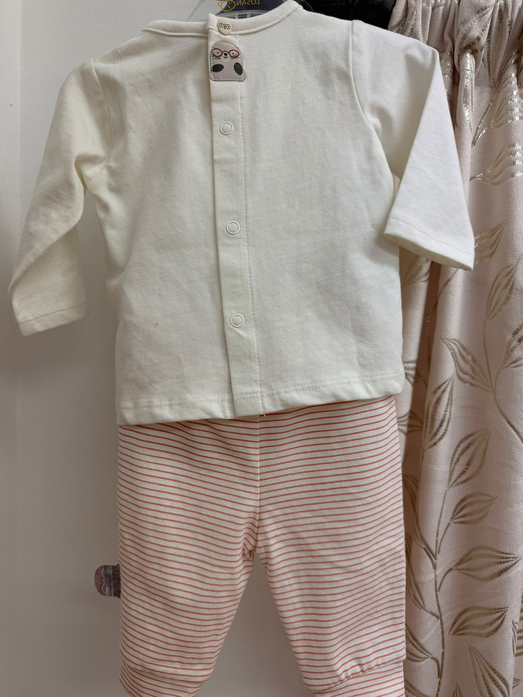 Vista trasera del conjunto bebé Talaman con pantalón de rayas coral